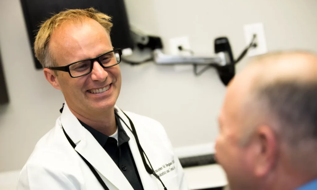 Dr. Christopher Bingham consulting with a dental implant patient at Council Oak Perio in Austin, Texas