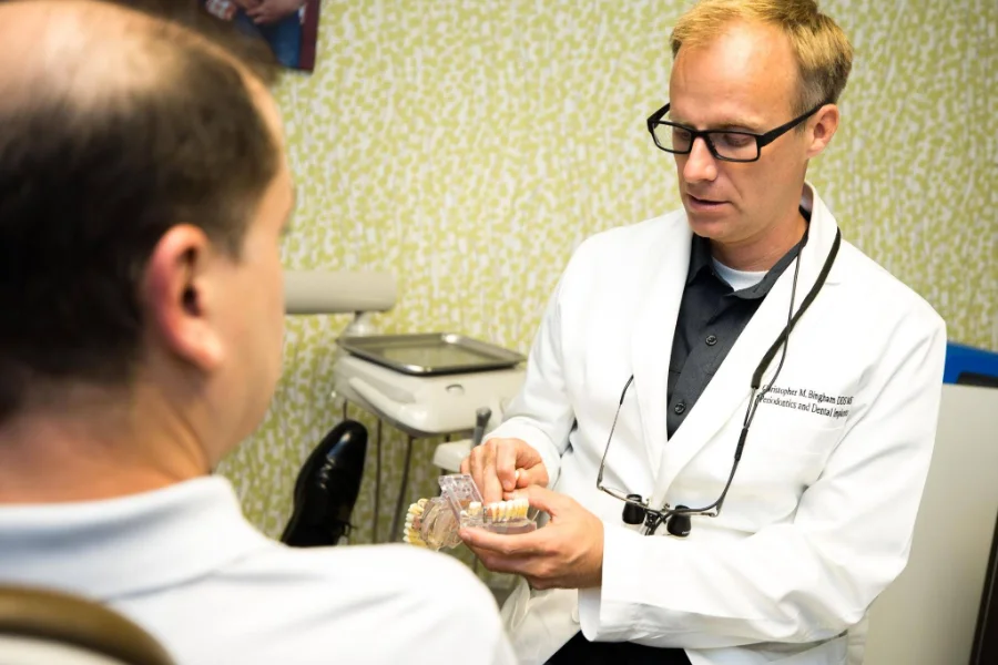 Dr. Christopher Bingham, board-certified periodontist, explaining peri-implantitis to a patient. Council Oak Perio in Austin, TX