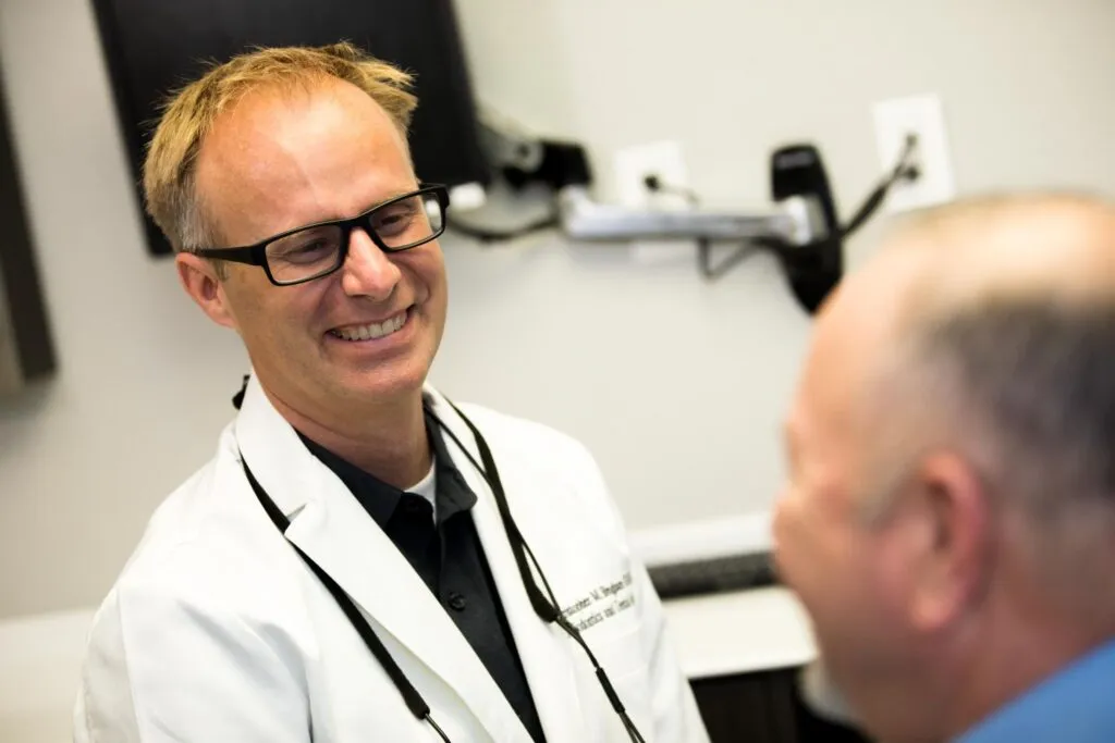 Dr. Christopher Bingham reviewing gum recession treatment options with a patient in Austin, TX