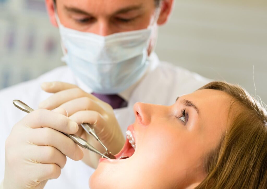 Dentist examining a patient's gums for gum recession during a routine dental checkup.